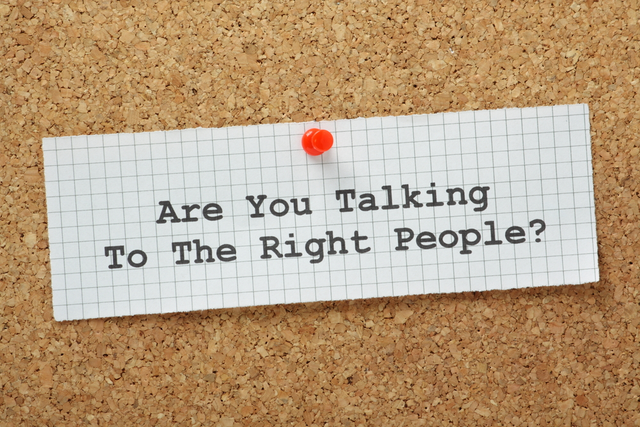 Bulletin board with a paper pinned on it that says, “Are you talking to the right people?”