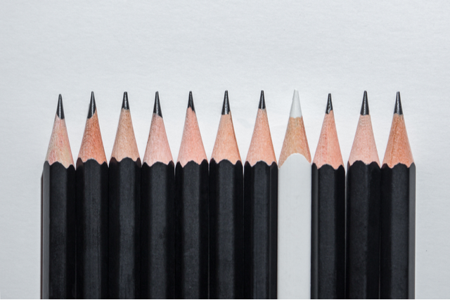 Sharp black and white pencils lined up on white background